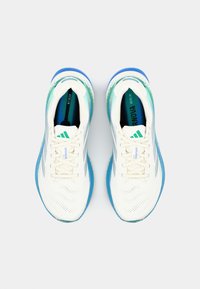 Baskets de sport blanches avec une tige en maille et des accents teal, dotées d'une semelle bleue et de lacets contrastés, conçues pour le confort et la performance.