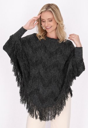 Poncho nero con frange, realizzato in un design a maglia testurizzato, con scollatura rotonda e maniche ampie, che si adagia dolcemente sul corpo.