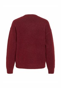 Bordeauxrode gebreide trui met een ontspannen pasvorm, lange mouwen en een ronde halslijn. Zachte textuur zonder zichtbare patronen of sieraden.