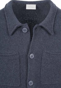 Donkergrijze cardigan met een geribbelde textuur, twee voorzakken, een kraag en vier knopen. Etiket zegt "Geschikt."