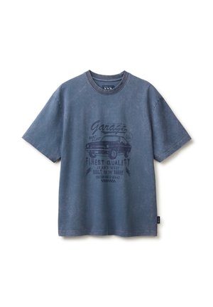 T-shirt blu sbiadita a maniche corte con grafica di un'auto vintage e testo "Garage Finest Quality Built for the Brave" sul davanti.