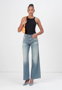 Black sleeveless bodysuit, light blue wide-leg jeans, orange handbag, silver heeled shoes, smooth texture, casual design.
