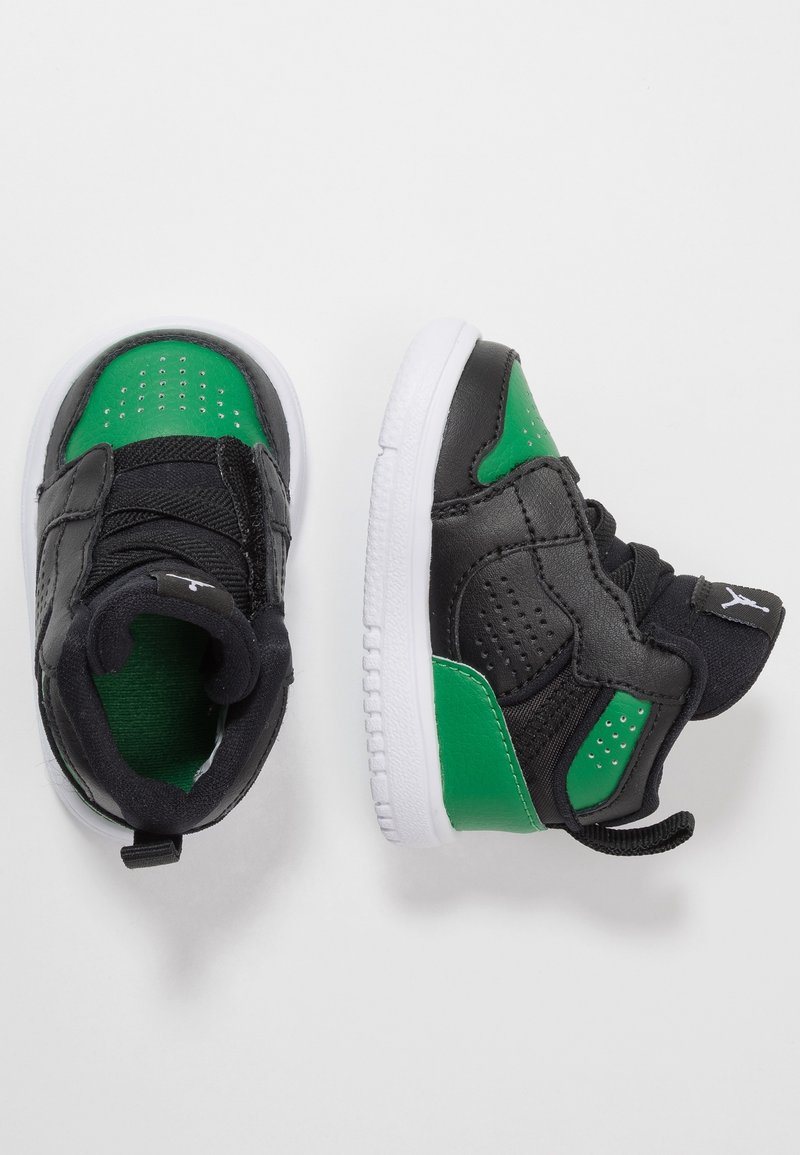 Dětské černozelené tenisky velikosti pro batole s bílou podrážkou leží na bílé ploše, přičemž jsou vidět přední a boční pohledy.