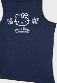 Námornícky top bez rukávov s grafikou Hello Kitty, obsahujúci biele potlačené texty a motívy mušlí. Vyrobený z mäkkej bavlny s rebrovanou textúrou.