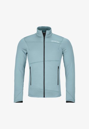 Helleblaue Zip-Jacke mit hohem Kragen, aus weichem Material, mit schwarzen Reißverschlüssen und Nahtakzenten sowie zwei Seitentaschen.