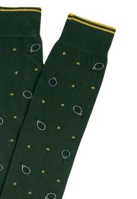 Calze verdi lavorate a maglia con una texture a coste, caratterizzate da un motivo di punti gialli e motivi di racchette da tennis in blu chiaro e grigio. Polsino a strisce gialle.