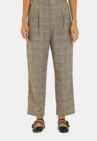 Pantalons à carreaux dans un motif multicolore avec une taille haute, un devant plissé et des jambes droites, fabriqués à partir d'un tissu texturé. Chaussures noires portées.