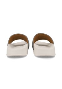 Lätta sandaler med ett grått band och texturerad brun innersula, med en tjock vit sula och en slät yta.