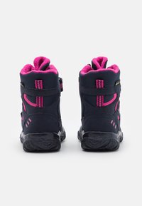 Juodi ir rožiniai aukšti batai su tekstūruota gumine puse, pūkuota pamušalu ir reguliuojamomis juostelėmis. Pabrėžia rožines detales ir siuvinėjimus.