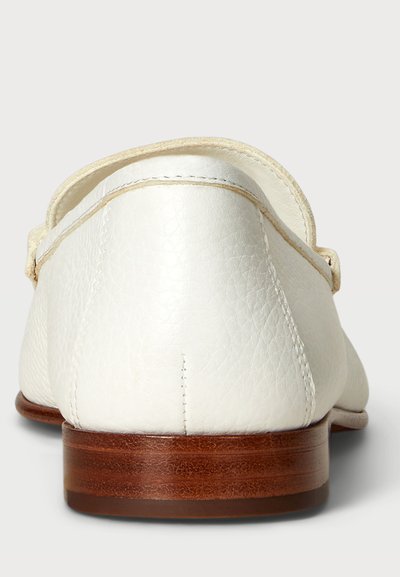 Baltie ādas loafers ar redzamu tekstūru, noapaļota forma un brūns koka papēdis. Iekļauj šuvju detaļas gar malām un aizmugurējo aizdari.