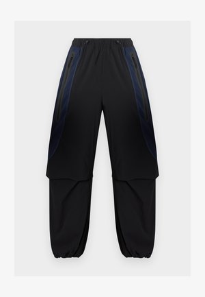 Czarne i ciemnoniebieskie spodnie bojówki z elastycznym pasem i mankietami, wyposażone w zapinane na zamek boczne kieszenie oraz warstwowe panele materiału na udach.