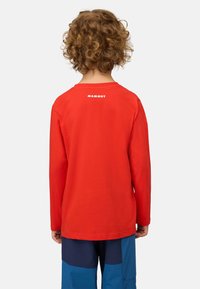 Langärmliges rotes T-Shirt aus Baumwolle mit rundem Ausschnitt und weißem "Mammut"-Logo auf dem Rücken, getragen von einem Kind.