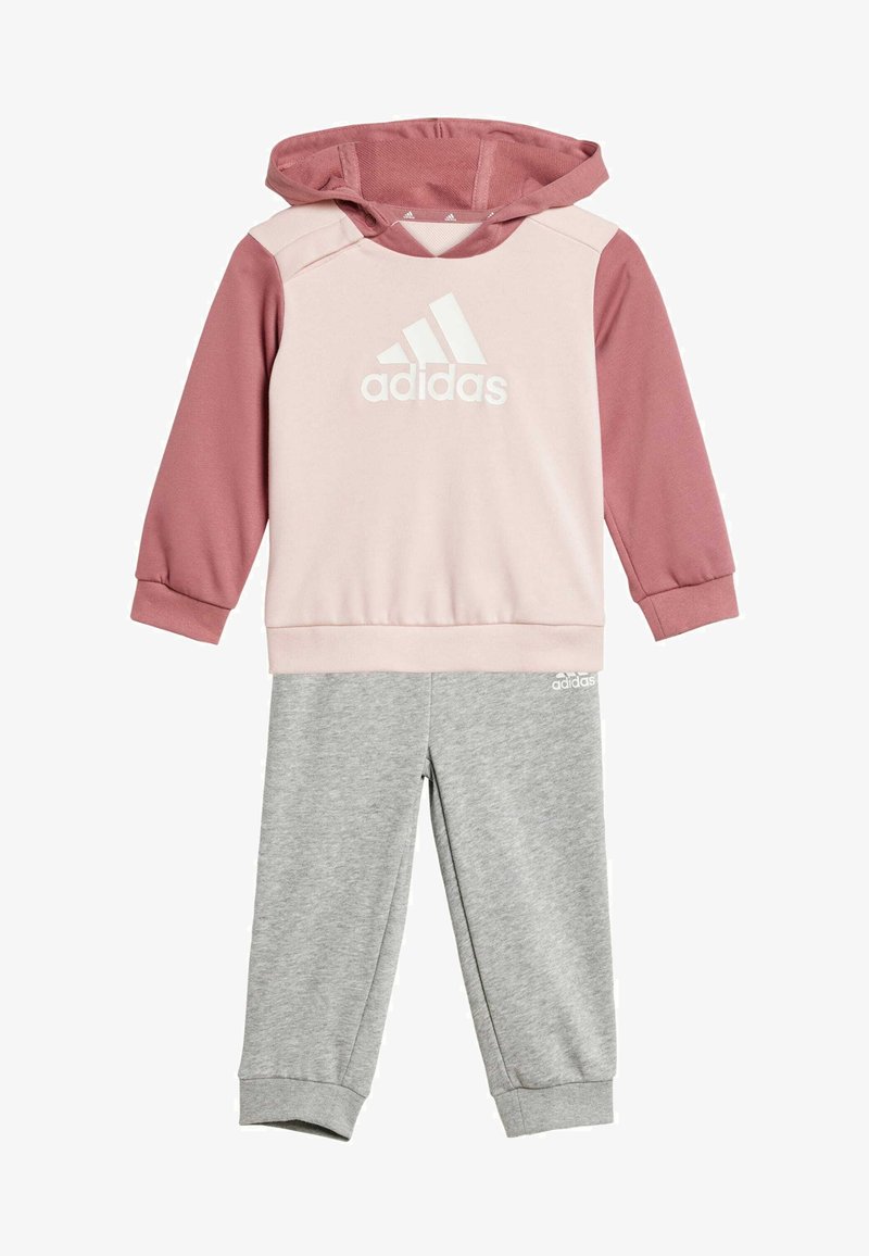 Conjunto de dos piezas de Adidas que incluye una sudadera con capucha en rosa claro y burdeos con un logo blanco, y pantalones de chándal grises con puños acanalados.
