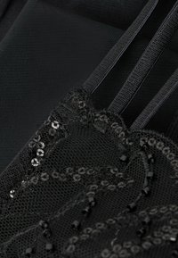 Tela de encaje negro con intrincados patrones florales adornados con lentejuelas y cuentas, complementada con malla texturizada y tirantes de satén.