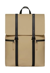 Zaino beige realizzato in materiale resistente, con un lembo pieghevole, spallacci e inserti neri, e due tasche con cerniera sul davanti.