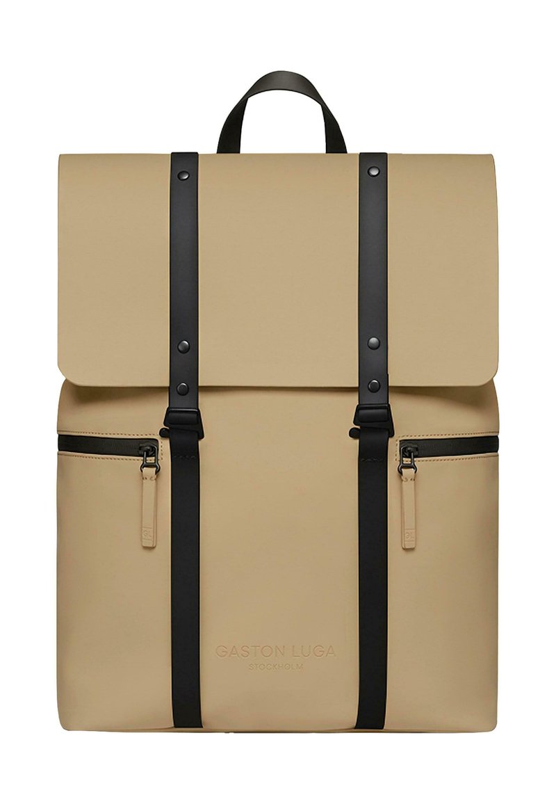 Zaino beige realizzato in materiale resistente, con un lembo pieghevole, spallacci e inserti neri, e due tasche con cerniera sul davanti.