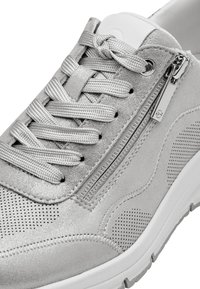 Silver athletic shoe featuring a textured upper with a metallic finish, contrasting laces, and a side zipper. Rubber sole with traction pattern.