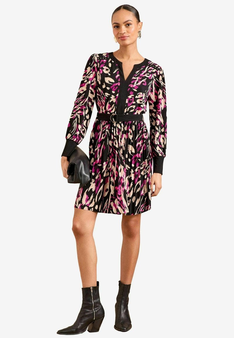 Poliester haljina s apstraktnim uzorkom u crnoj, ružičastoj i krem boji. Ima V-izrez, duge rukave i suženi struk s remenom.