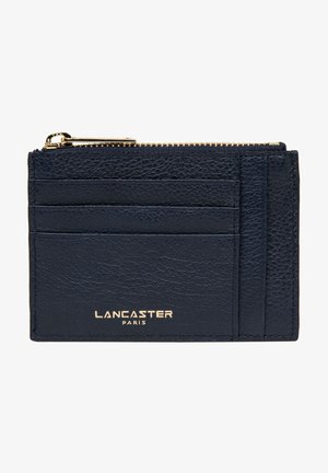 Porte-cartes en cuir marine avec quatre emplacements pour cartes, poche zippée et logo doré. La finition texturée ajoute de la profondeur et un intérêt tactile.