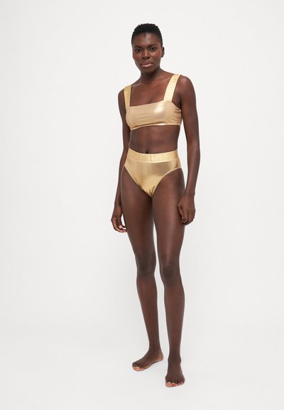 Gull metallisk bikini-sett med firkantet bralette og høyt liv-bunn. Stroppene og midjebåndet har et teksturert design. Glatt overflate.