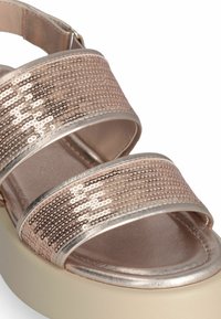 Rose gold platform sandal with three wide sequin straps, a smooth metallic finish, and a light-colored thick sole.