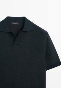 Polo nera a maniche corte con trama, colletto aperto ed etichetta "Massimo Dutti" all'interno sul retro del collo.