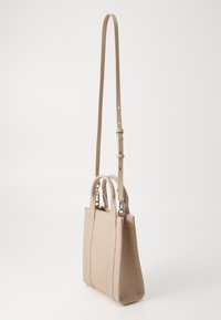 Beige håndveske med en strukturert design, to korte håndtak, og en avtagbar lang stropp. Laget av teksturert stoff med diskrete vertikale sømmer.