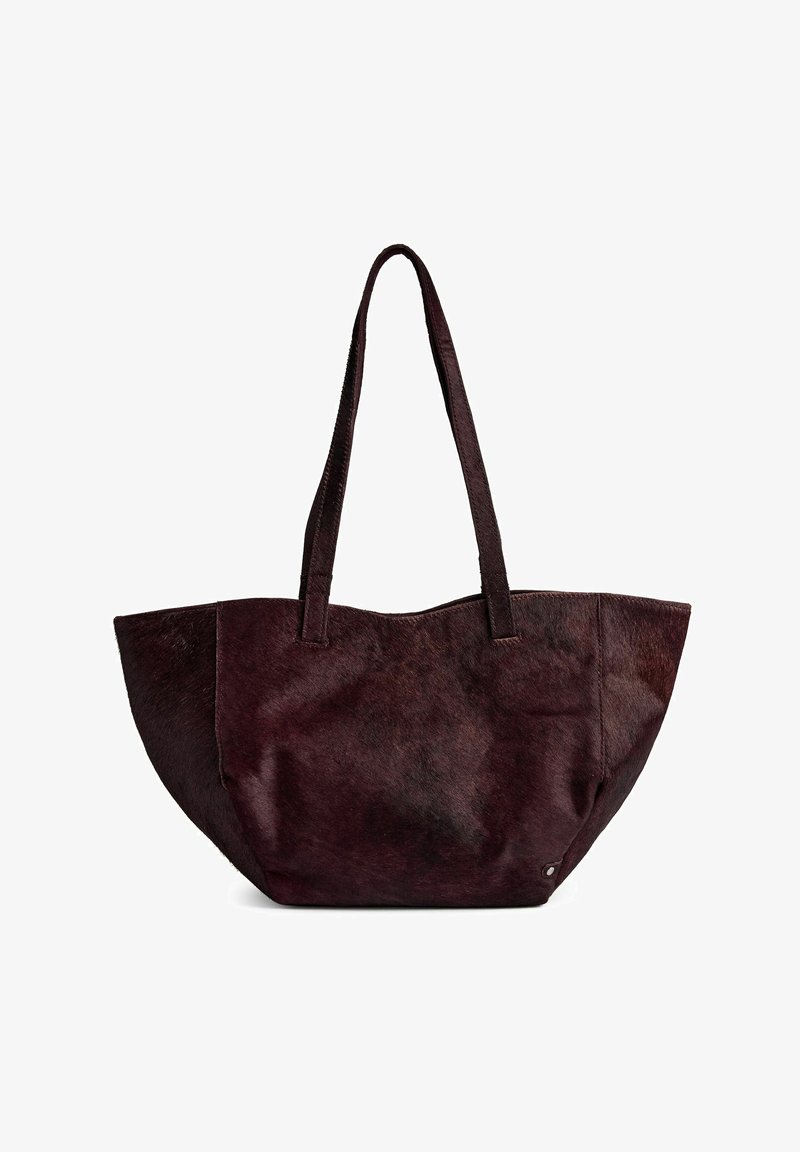 Tmavě burgundská taška přes rameno vyrobená z měkké kůže s chlupem, s dvěma robustními uchy a prostorným otevřeným vrchem bez zapínání.