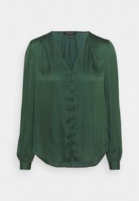 Blusa verde a maniche lunghe in tessuto liscio. Scollatura a V, chiusura frontale con bottoni e spalle arricciate con maniche a polsino. Orlo arrotondato.