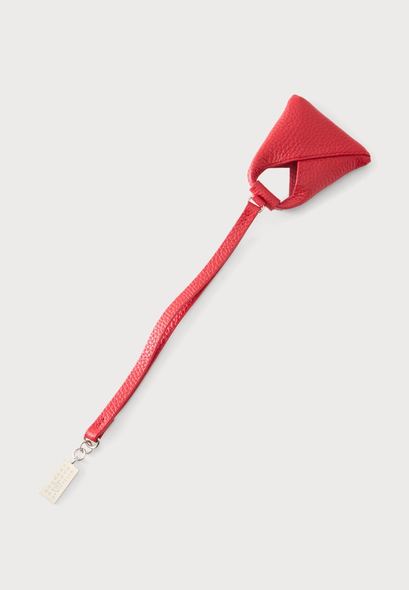 Bracelet de poignet en cuir rouge avec un support triangulaire rembourré et une étiquette métallique argentée attachée à l'extrémité sur un fond clair.