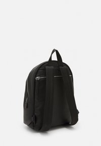 Czarny plecak z teksturowanej ekoskóry z dwoma szelkami na ramiona, uchwytem na górze oraz poziomą kieszenią na zamek błyskawiczny na tylnej części.