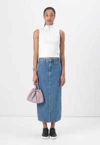 Vit ärmlös topp med dragkedja, högmidjad blå denimkjol, svarta sneakers, håller en liten lavendelväska. Enkelt mönster, mjuka texturer.