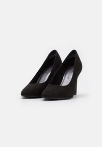 Zapatos de tacón alto de ante negro con punta afilada y tacón stiletto delgado; presenta una textura suave y un diseño minimalista.