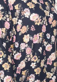 Marinfärgat tyg med ett blommönster som har rosa, gula och vita blommor. Texturen verkar mjuk, med intrikata detaljer i blomdesignen.