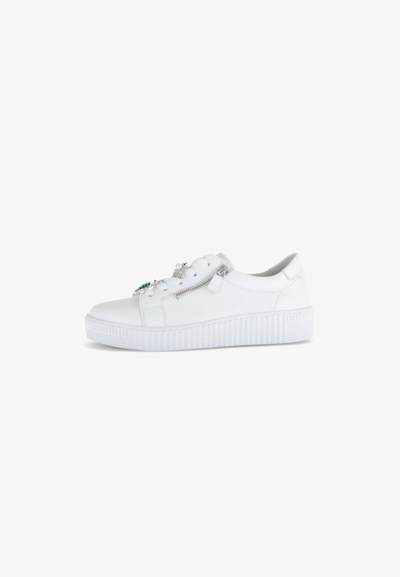 White sneaker with textured rubber sole, rounded toe, zipper detail, and decorative accents. Made of synthetic leather for durability.