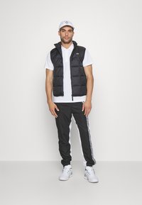 Lacoste Sport TENNIS PANT - Pantalones deportivos - noir/blanc