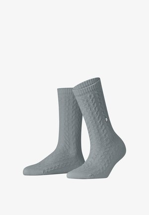 Par de calcetines tejidos de color gris claro con un sutil patrón de cables y un pequeño detalle redondo plateado en un lado.