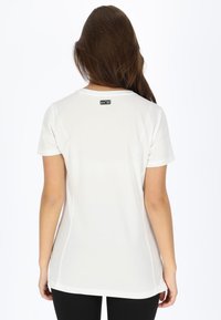 Hvid kortærmet T-shirt med buet kant, glat tekstur og et lille sort mærke i nakken på bagsiden.