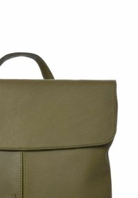 Mochila de cuero verde oliva con solapa plegable, costuras visibles y un asa superior. Textura suave con hardware mínimo.