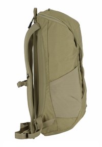 Sac à dos kaki de forme rectangulaire, fabriqué en tissu texturé. Il possède des bretelles rembourrées, des accents en maille et une poche latérale pour le rangement.