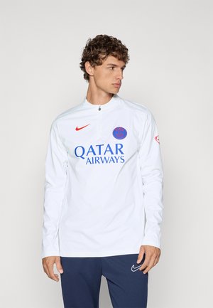 Bela dolgimi rokavi trening majica z visokim ovratnikom, z rdečim logotipom Nike in modrim motivom "Qatar Airways" spredaj.