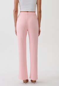 Roze, op maat gemaakte broeken met een gladde textuur, hoge taille en uitlopende pijpen. Voorzien van een achterste rits en keurig afgewerkte zoom.