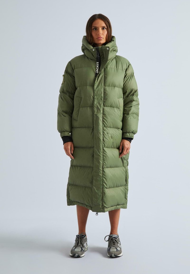 Garšs, pūkains zaļš mētelis ar kapuci, ar ievelkamiem priekšējiem kabatām, divām sānu kabatām un elastīgām aprocēm. Nēsāts pār tumšu apģērbu un sporta apaviem.