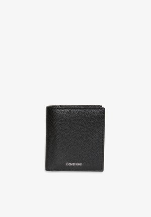 Portafoglio bifold in pelle nera texturizzata con logo Calvin Klein argento centrato vicino al bordo inferiore, mostrato chiuso su sfondo bianco.
