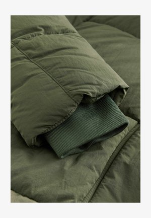 Dunkelgrüne Daunenjacke mit geripptem Bündchen. Verfügt über ein gestepptes Design, eine glatte Textur und einen umgeschlagenen Kragen. Minimalistischer und funktionaler Stil.