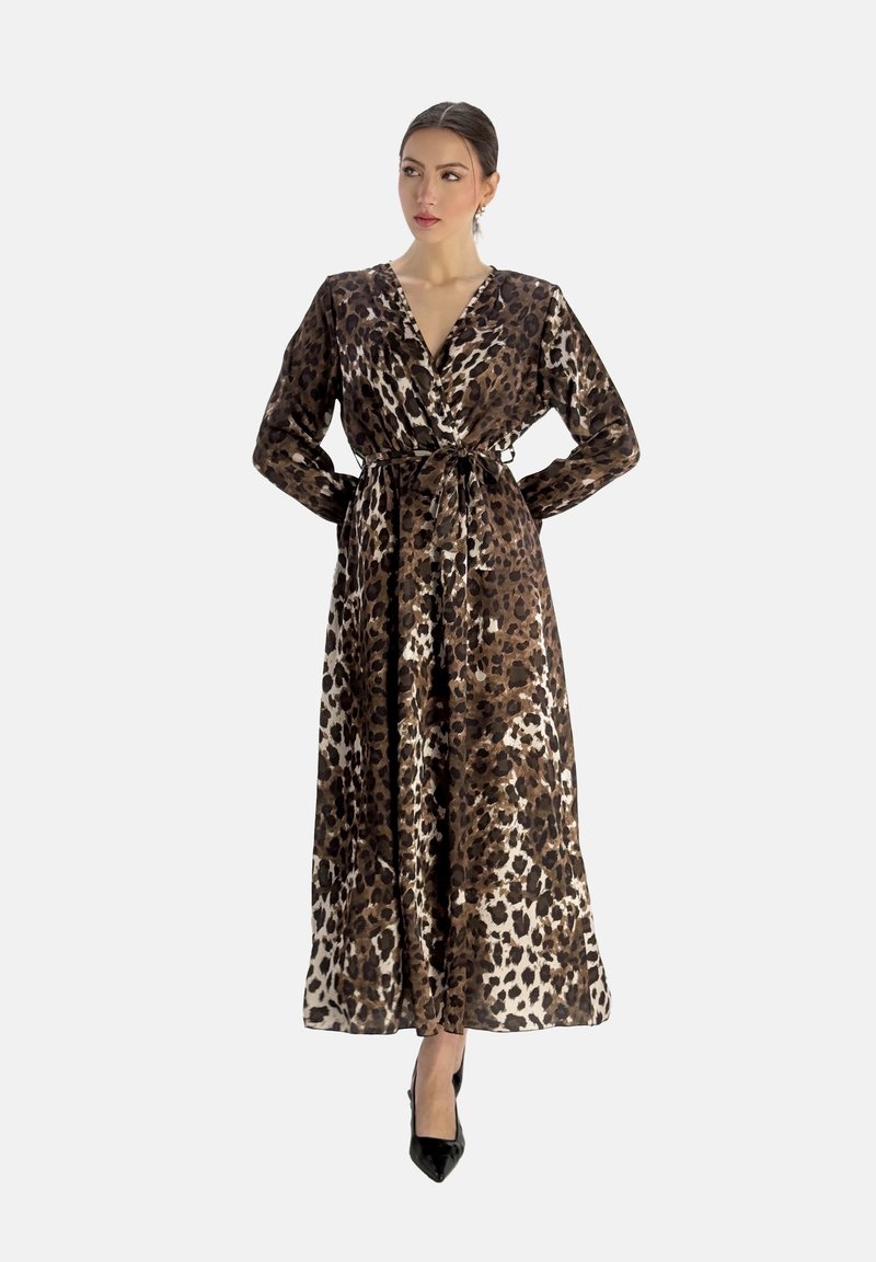 Robe en imprimé léopard en tissu lisse, avec un décolleté en V, une taille ceinturée, des manches longues et une silhouette fluide. Talons noirs.