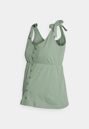 Jasnozielony top na ramiączkach z regulowanymi troczkami, zapinany na guziki z przodu, wykonany z miękkiego, elastycznego materiału zapewniającego wygodę i łatwość noszenia.