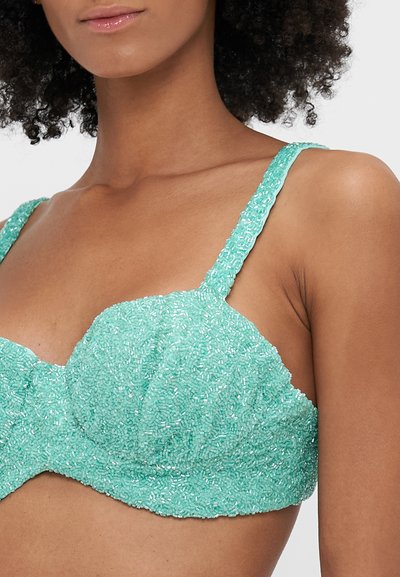 Bralette verde menta com embellishments texturizados, apresentando alças ajustáveis e um design de copo estruturado. Decorado com pérolas intrincadas.