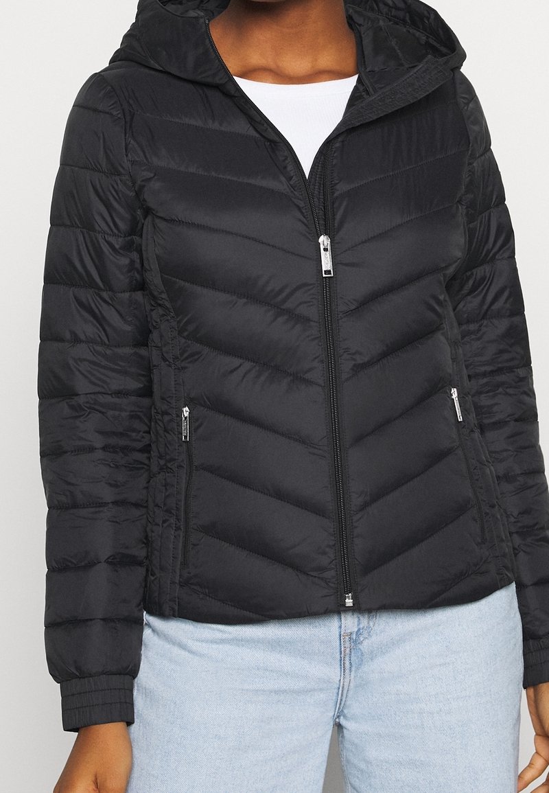 Doudoune noire avec capuche, présentant un zip à l'avant, un design matelassé en chevrons et deux poches latérales zippées.