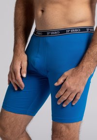 Boxers azules ajustados con una textura suave, con una cinturilla negra con la marca "JP1880". El diseño es ajustado y de longitud media en los muslos.